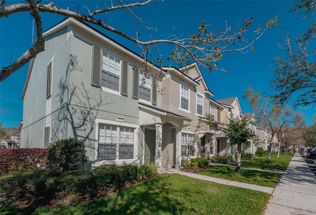 view of property with a residential view, a front lawn, and stucco siding