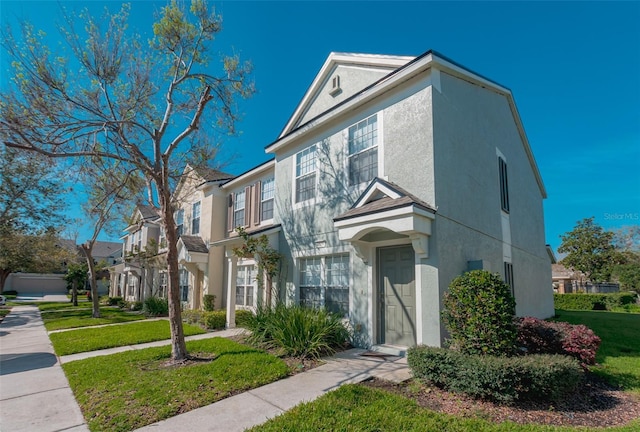 multi unit property featuring a front yard, a residential view, and stucco siding