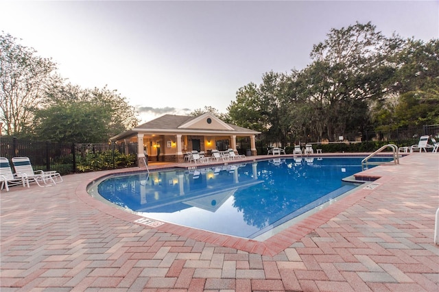 community pool featuring fence and a patio