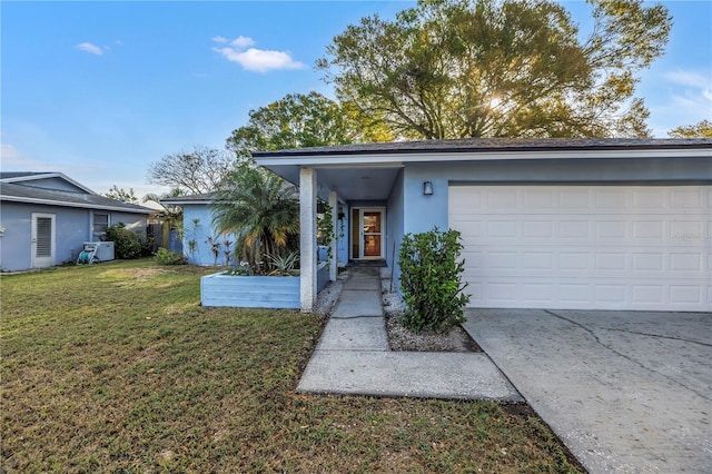 view of front facade with driveway, an attached garage, a front lawn, and stucco siding