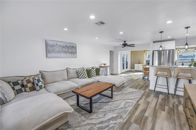 living area featuring a ceiling fan, visible vents, dark wood-type flooring, and recessed lighting