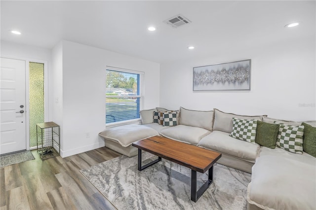 living area featuring baseboards, wood finished floors, visible vents, and recessed lighting