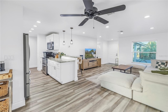 living room with light wood-style floors, baseboards, a ceiling fan, and recessed lighting