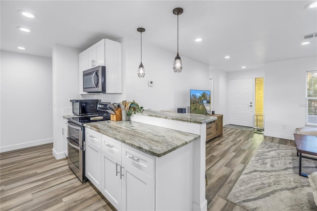 kitchen with recessed lighting, stainless steel appliances, a peninsula, visible vents, and light wood finished floors