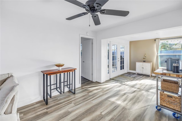 sitting room featuring a ceiling fan, french doors, baseboards, and wood finished floors