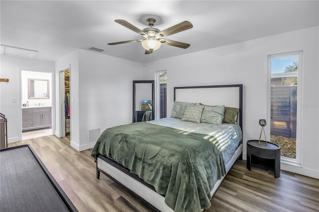 bedroom with baseboards, light wood-type flooring, visible vents, and attic access