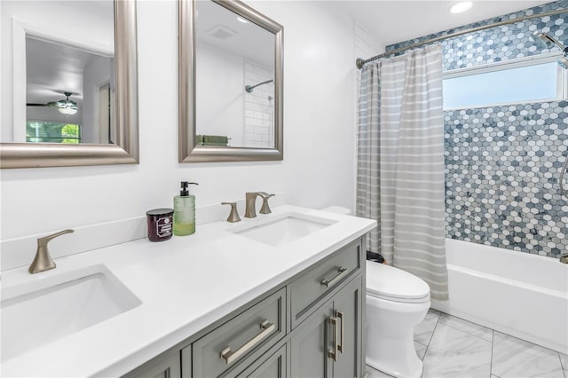 bathroom featuring toilet, marble finish floor, double vanity, and a sink