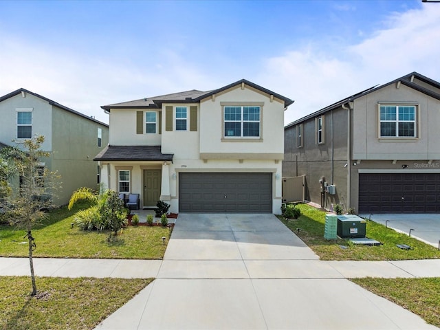 view of front of home with an attached garage, driveway, a front yard, and stucco siding