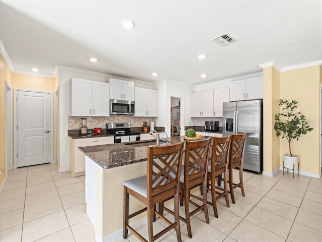 kitchen with light tile patterned floors, stainless steel appliances, visible vents, ornamental molding, and a sink