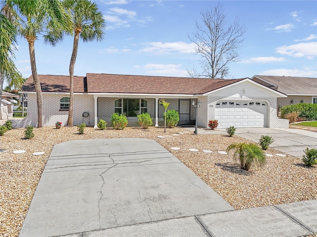 single story home with an attached garage, brick siding, driveway, and a shingled roof