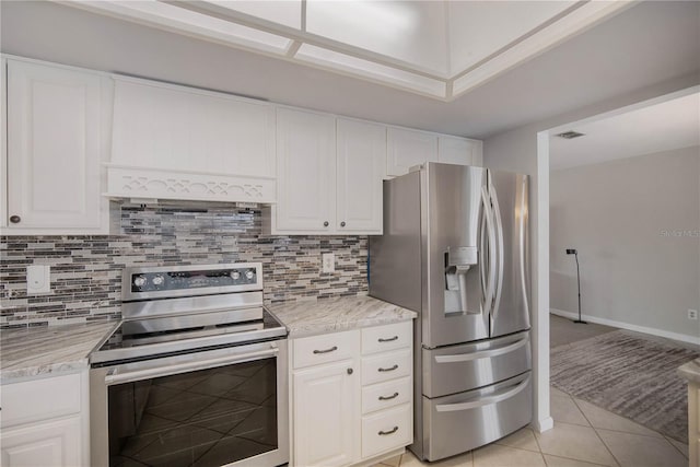 kitchen with tasteful backsplash, white cabinetry, stainless steel appliances, and light tile patterned flooring