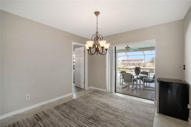 dining room featuring light tile patterned flooring, a notable chandelier, and baseboards