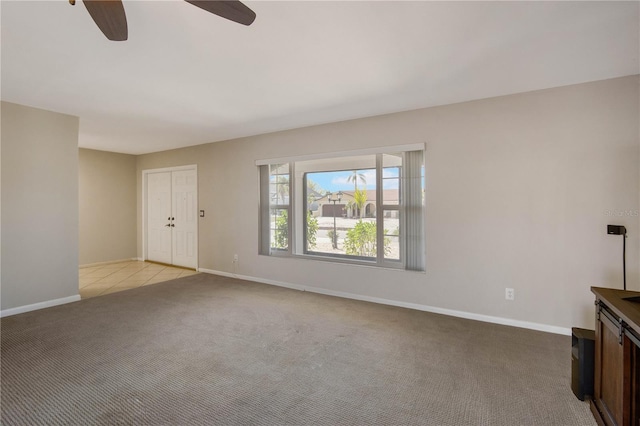 unfurnished living room with light colored carpet, baseboards, and ceiling fan