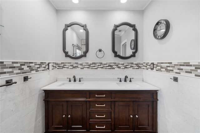 bathroom featuring double vanity, wainscoting, tile walls, and a sink