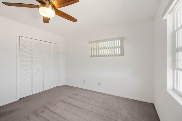 unfurnished bedroom featuring a closet, multiple windows, and carpet