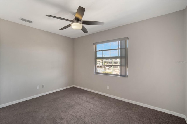 unfurnished room with visible vents, baseboards, ceiling fan, and dark carpet