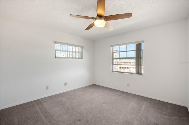 carpeted empty room featuring a textured ceiling, baseboards, and a ceiling fan