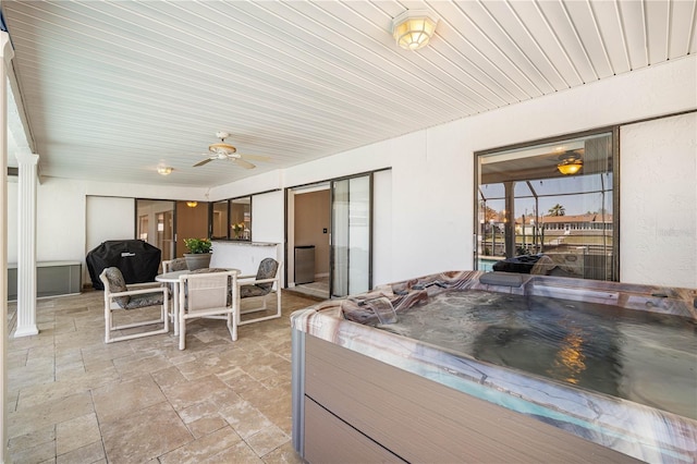 view of patio / terrace featuring ceiling fan, area for grilling, outdoor dining area, and a hot tub