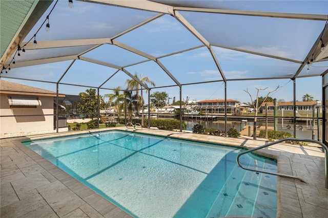 outdoor pool with glass enclosure, a patio, and a water view