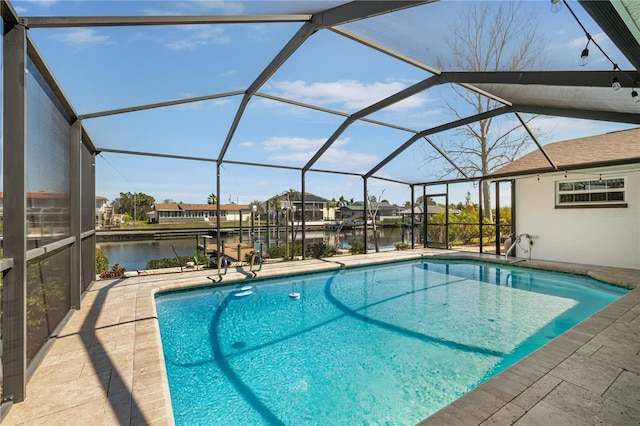 pool featuring glass enclosure, a water view, and a patio area