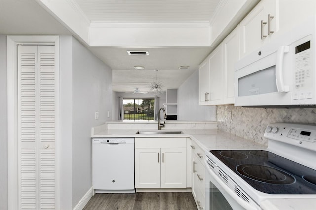 kitchen with white appliances, crown molding, visible vents, and a sink