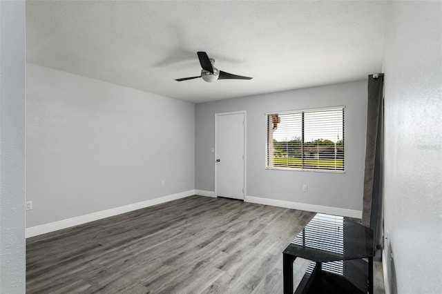 unfurnished room with a ceiling fan, baseboards, and wood finished floors