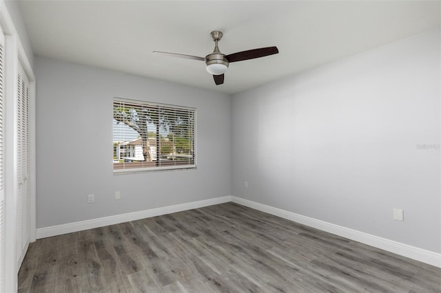 unfurnished bedroom with ceiling fan, a closet, wood finished floors, and baseboards