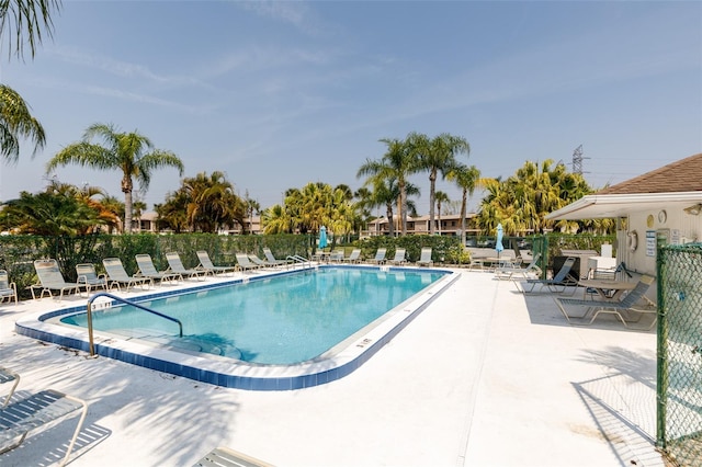 community pool featuring fence and a patio