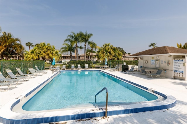 pool with a patio and fence