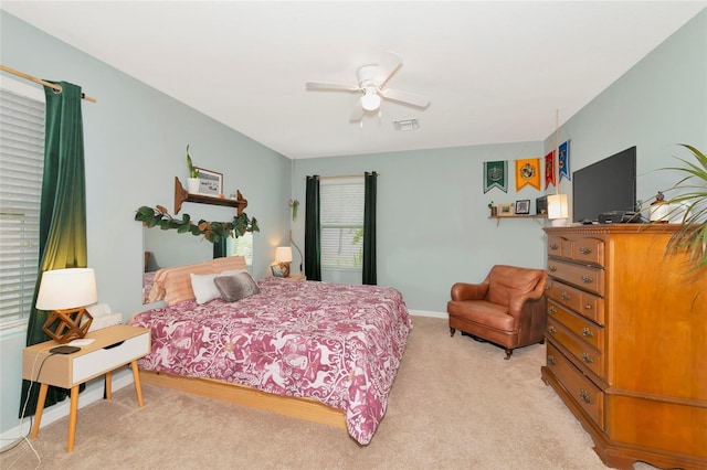 bedroom with ceiling fan, baseboards, visible vents, and light colored carpet