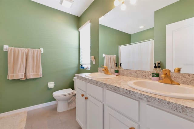 bathroom featuring double vanity, tile patterned flooring, a sink, and toilet