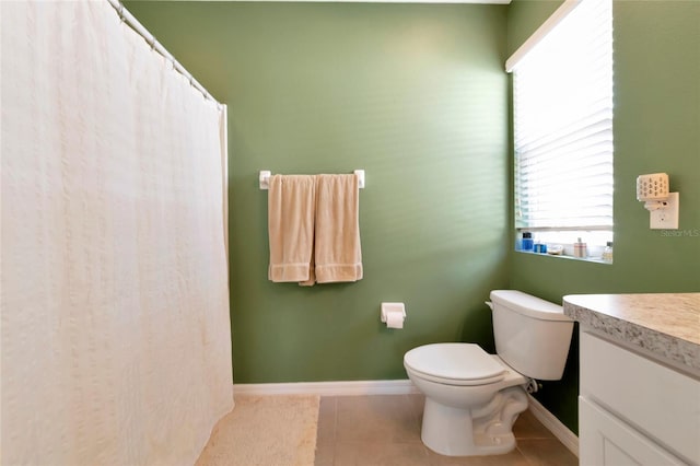 bathroom with baseboards, vanity, toilet, and tile patterned floors