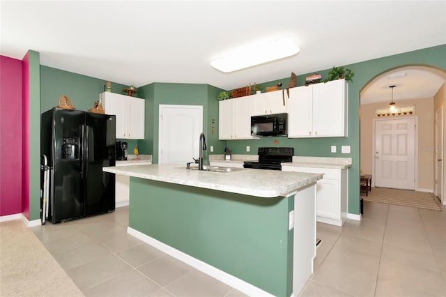 kitchen with arched walkways, black appliances, light countertops, and white cabinets