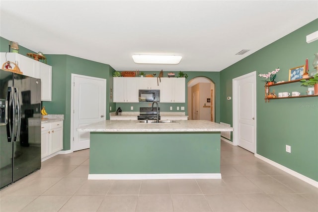 kitchen with arched walkways, light countertops, white cabinets, a sink, and black appliances