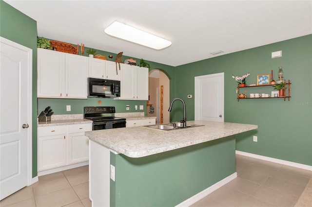 kitchen featuring arched walkways, light countertops, black appliances, white cabinetry, and a sink