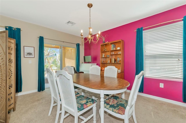 carpeted dining room featuring baseboards, visible vents, and a notable chandelier