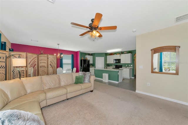 living area featuring baseboards, carpet, visible vents, and a ceiling fan