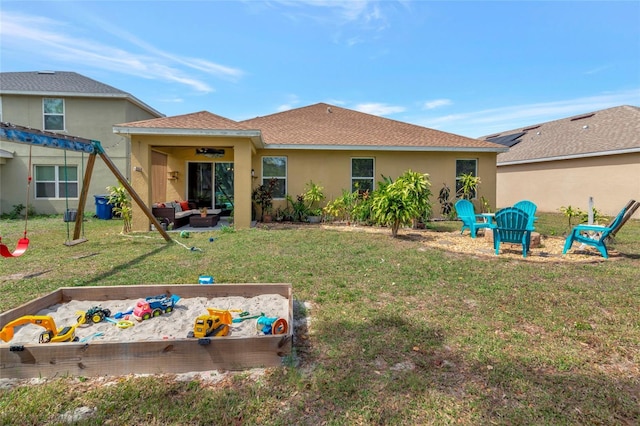 rear view of property with a yard, a patio area, outdoor lounge area, and stucco siding