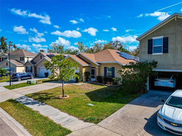 view of front facade with concrete driveway, a front lawn, solar panels, and stucco siding