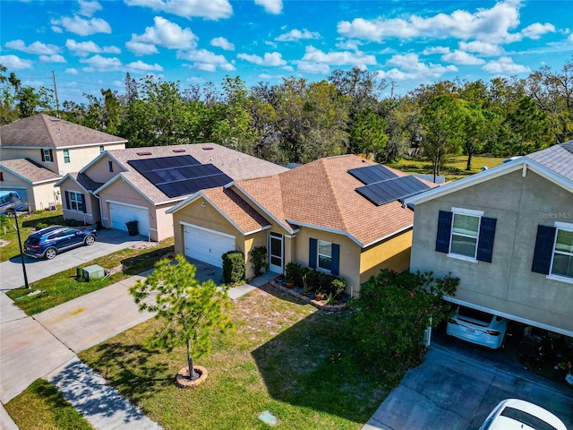 view of front of house featuring driveway, roof with shingles, an attached garage, a front lawn, and stucco siding