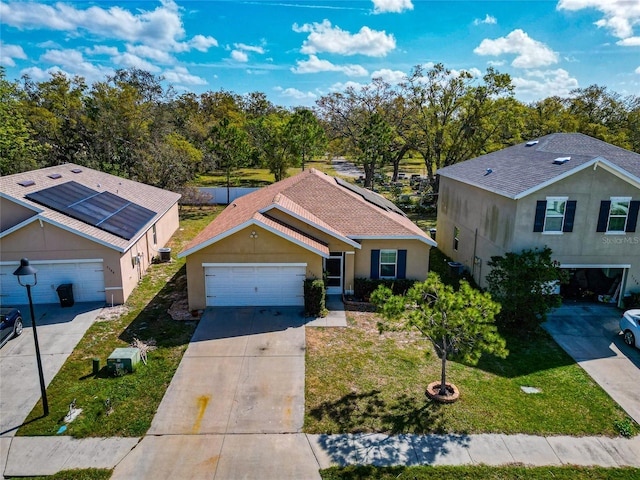 view of front of home with a garage, driveway, roof with shingles, a front lawn, and stucco siding