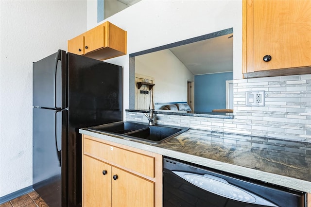 kitchen featuring baseboards, decorative backsplash, black appliances, light brown cabinets, and a sink