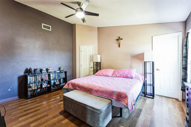 bedroom featuring a textured ceiling, ceiling fan, wood finished floors, and visible vents