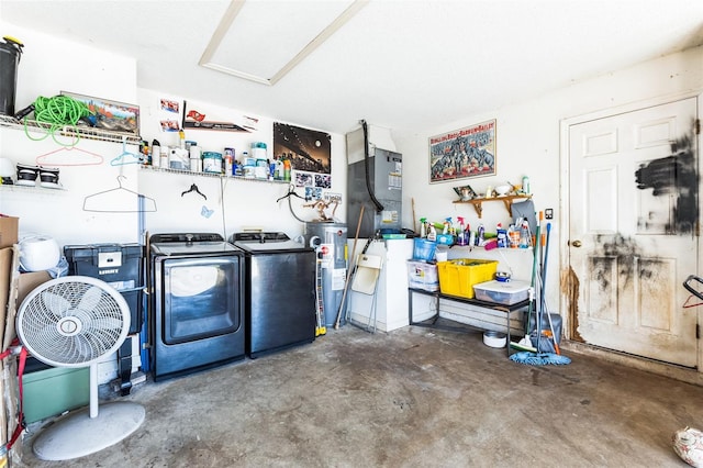 clothes washing area with laundry area, washing machine and dryer, and electric water heater