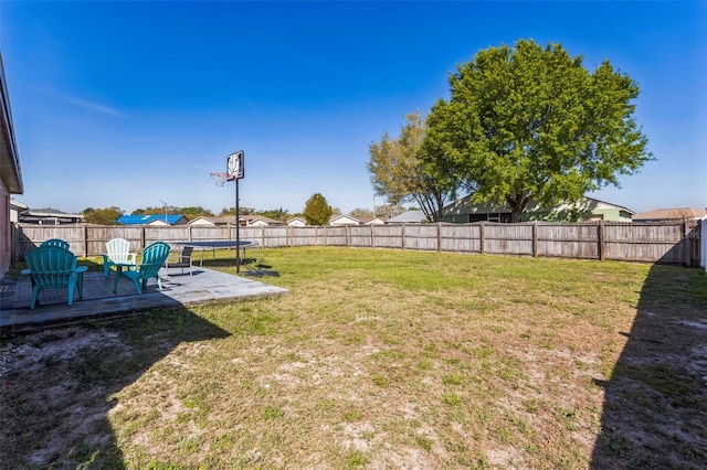 view of yard with a patio, a trampoline, and a fenced backyard