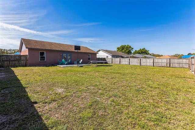 view of yard with a trampoline, a patio area, and a fenced backyard