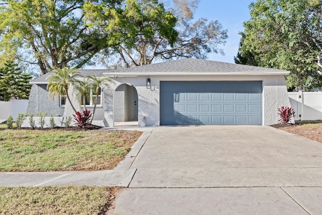 ranch-style house with a garage, concrete driveway, fence, and stucco siding