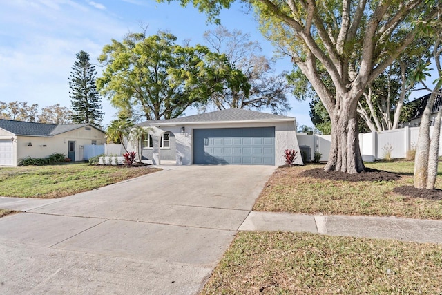 ranch-style home featuring a garage, fence, driveway, stucco siding, and a front lawn