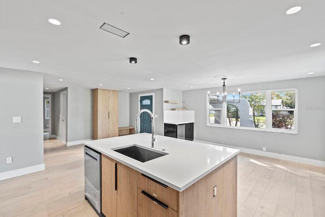 kitchen with light wood-type flooring, a sink, dishwasher, and recessed lighting