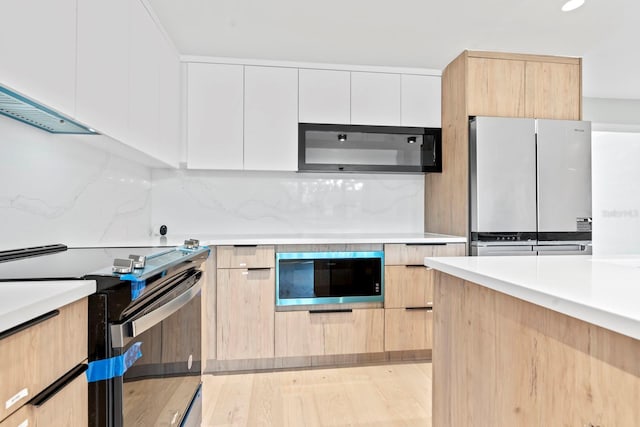 kitchen featuring stainless steel electric range oven, freestanding refrigerator, modern cabinets, built in microwave, and black microwave